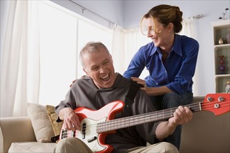 Man playing electric guitar with woman. Photo : Rob Lewine