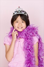 Studio portrait of teenage (16-17) girl wearing tiara and feather boa. Photo : Rob Lewine
