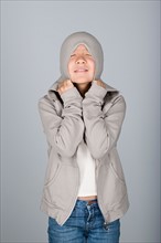 Studio shot portrait of teenage girl in hooded shirt, waist up. Photo : Rob Lewine