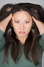 Studio portrait of stressed Chinese woman. Photo : Rob Lewine