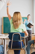 Girl rising hand in classroom. Photo : Rob Lewine