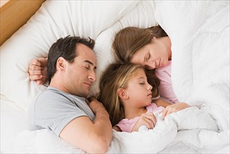Parents with daughter (12-13) sleeping in bed. Photo : Rob Lewine