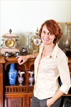 Smiling woman with her collection of antiques. Photo :  Elena Elisseeva