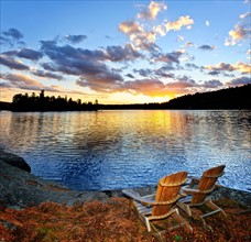 Canada, Ontario, Algonquin Park, Adirondack chairs on edge of lake. Photo :  Elena Elisseeva
