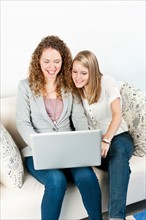 Two young women using laptop. Photo : Elena Elisseeva