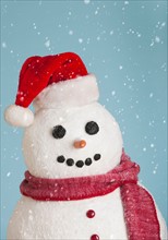 Studio shot of snowman wearing Santa hat.