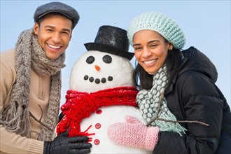 Portrait of couple with snowman.