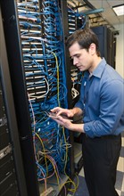 Technician inspecting network server.