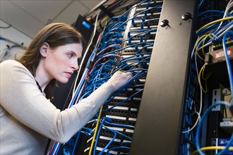 Female IT support technician repairing server.