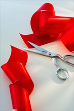 Studio shot of red ribbon and scissors.