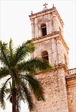 Mexico, Yucatan, Valladolid. Valladolid, Bell tower and palm tree.