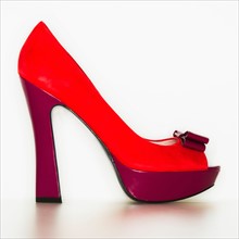 Studio shot of red high heel open toe shoe.