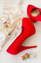 Studio shot of red stilettos glass of wine and cork.