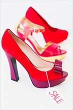 Red high heel shoes with price tag.