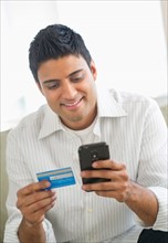 Man holding credit card and smart phone.