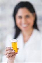 Hand of pharmacist holding pill bottle.