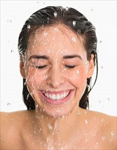 Studio shot of woman with splash of water on face.