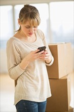 Woman using smart phone during relocation.