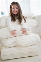 Small girl  (4-5 years) playing with cushions. Photo : Jamie Grill