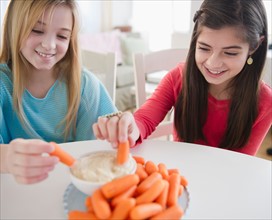 Two girls eating carrots. Photo : Jamie Grill