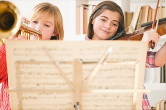 Two girls playing instruments from sheet music. Photo : Jamie Grill