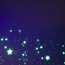 Fluorescent stars on blue background, studio shot. Photo : Jamie Grill