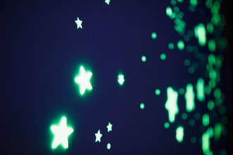Close up of fluorescent stars on blue background, studio shot. Photo : Jamie Grill