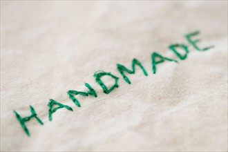Close up of embroided handmade word, studio shot. Photo : Jamie Grill
