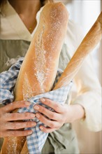 Close up of woman's hands holding baguette. Photo : Jamie Grill