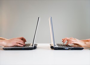 Close up of man's and woman's hands working with laptops. Photo : Jamie Grill
