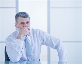 Portrait of businessman sitting at desk. Photo : Daniel Grill
