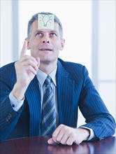Portrait of businessman with label on forehead. Photo : Daniel Grill