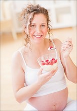 Portrait of pregnant woman eating breakfast. Photo : Daniel Grill