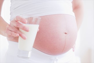 Pregnant woman with glass of milk. Photo : Daniel Grill