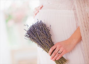 Pregnant woman holding bunch of lavender. Photo : Daniel Grill