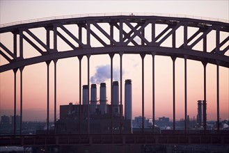 USA, New York, New York City. Bridge and smoke stacks at dusk. Photo : fotog