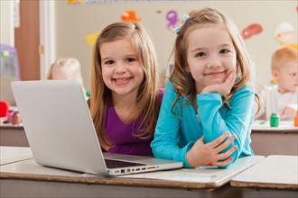Children (4-5, 6-7) at school using laptop. Photo : Mike Kemp