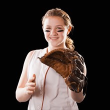Portrait of girl (12-13) plying softball, studio shot. Photo : Mike Kemp