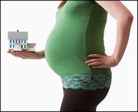 Pregnant woman holding architectural model. Photo : Mike Kemp