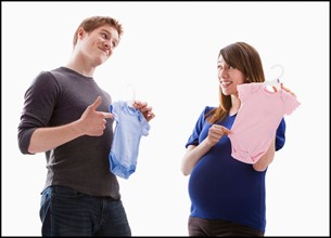 Studio Shot of young couple holding onesie. Photo : Mike Kemp