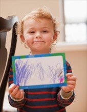 Boy (4-5) showing his drawing. Photo : Mike Kemp
