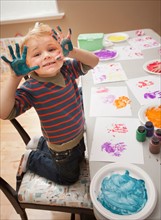 Boy (4-5) with paint covered hands. Photo : Mike Kemp