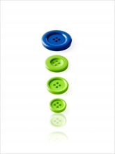 Studio shot of blue and green buttons in a row. Photo : David Arky
