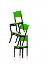 Studio shot of three green chairs stacked one on top of another. Photo : David Arky