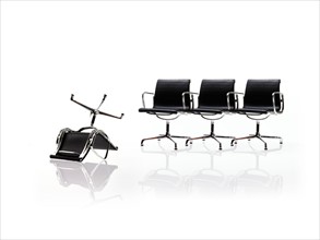 Row of corporate chairs, one upside down. Photo : David Arky