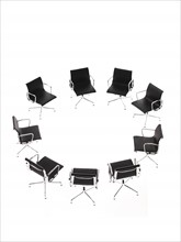 Corporate chairs forming circle on white background. Photo : David Arky