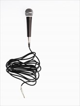 Studio shot of microphone and microphone cable on white background. Photo : David Arky