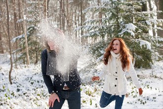 Netherlands, North-Brabant, Hilvarenbeek. Young couple are having snowball fight. Photo : Jan