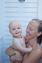 Mid adult woman having shower with her baby son (12-17 months) . Photo : Noah Clayton