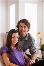 Portrait of young couple sitting on sofa. Photo : Rob Lewine